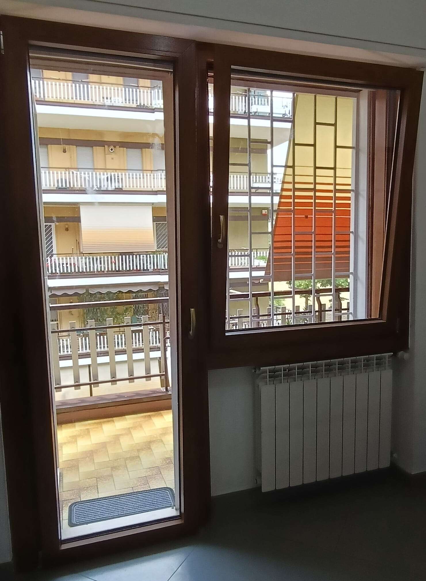 Infisso effetto legno con portafinestra che si apre su un balcone