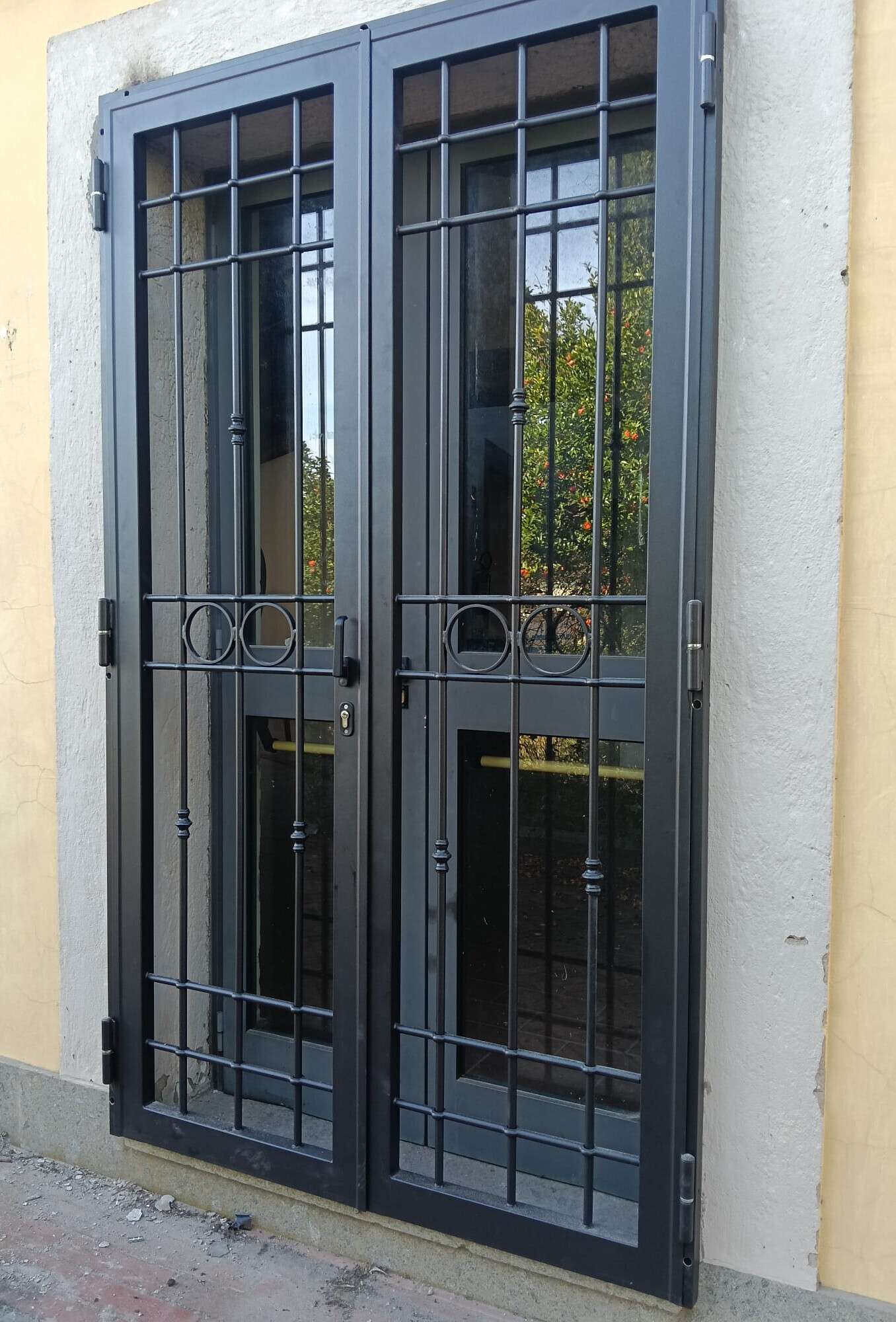 Grata di sicurezza nera a due ante installata davanti a una portafinestra