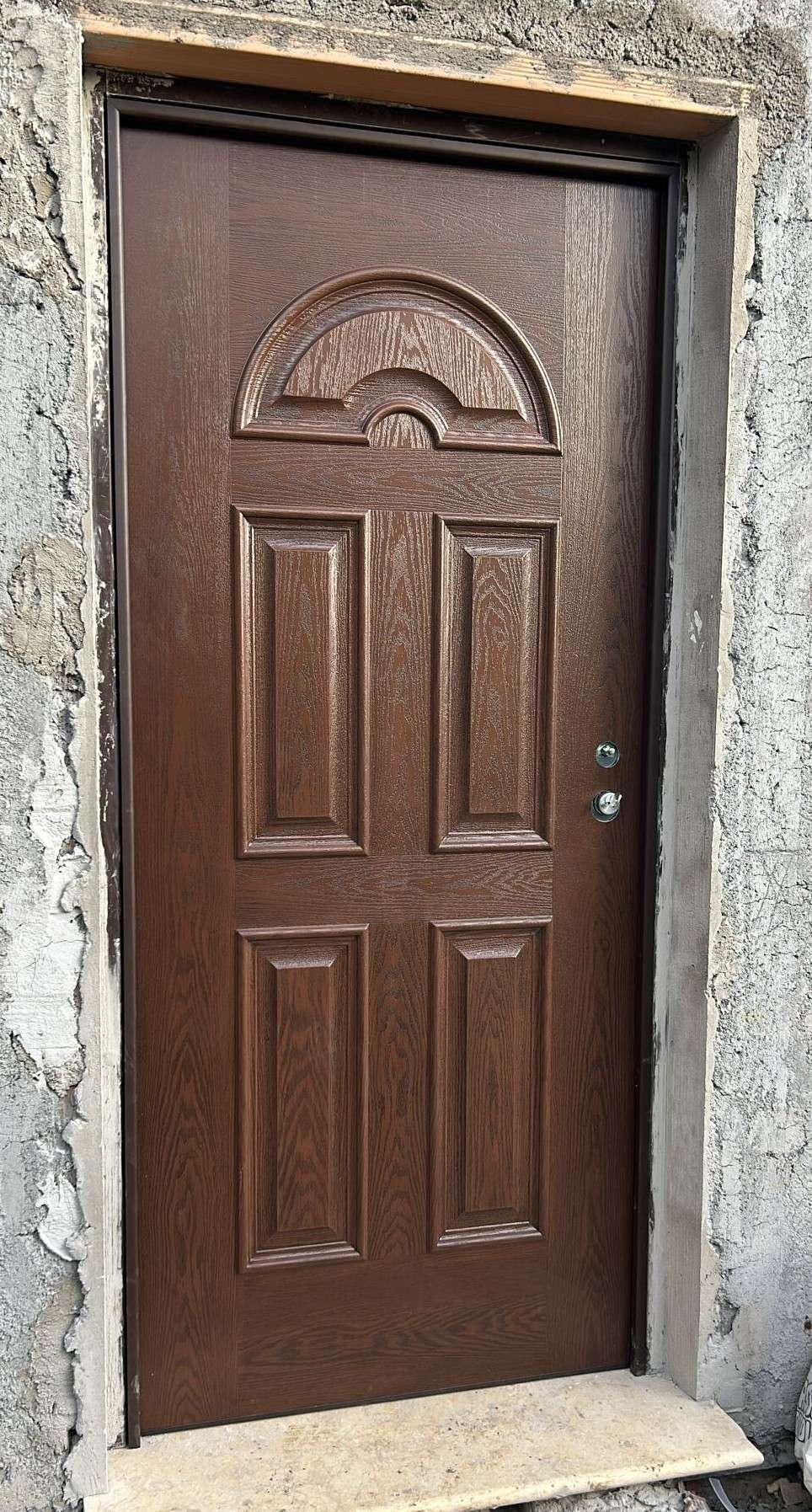 Porta blindata color noce con pannelli in rilievo e decoro a ventaglio